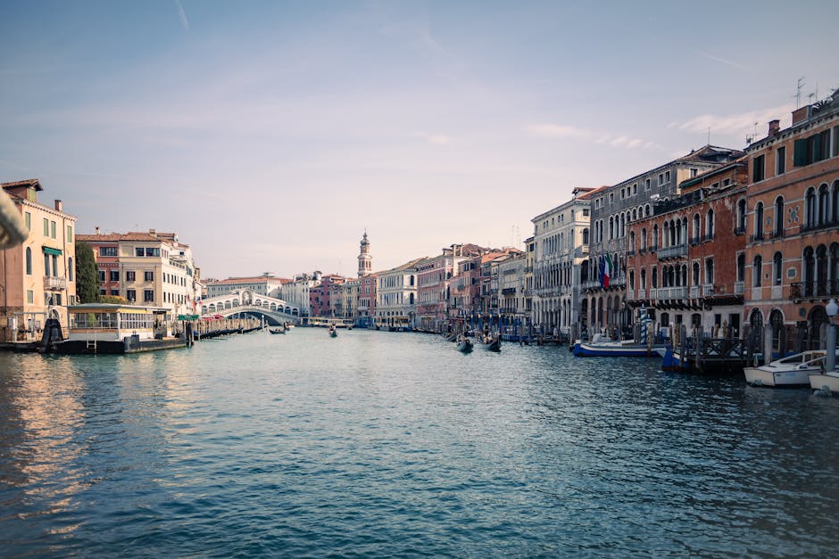 Beautiful capture of Venice's Grand Canal featuring the iconic Rialto Bridge under a clear sky.