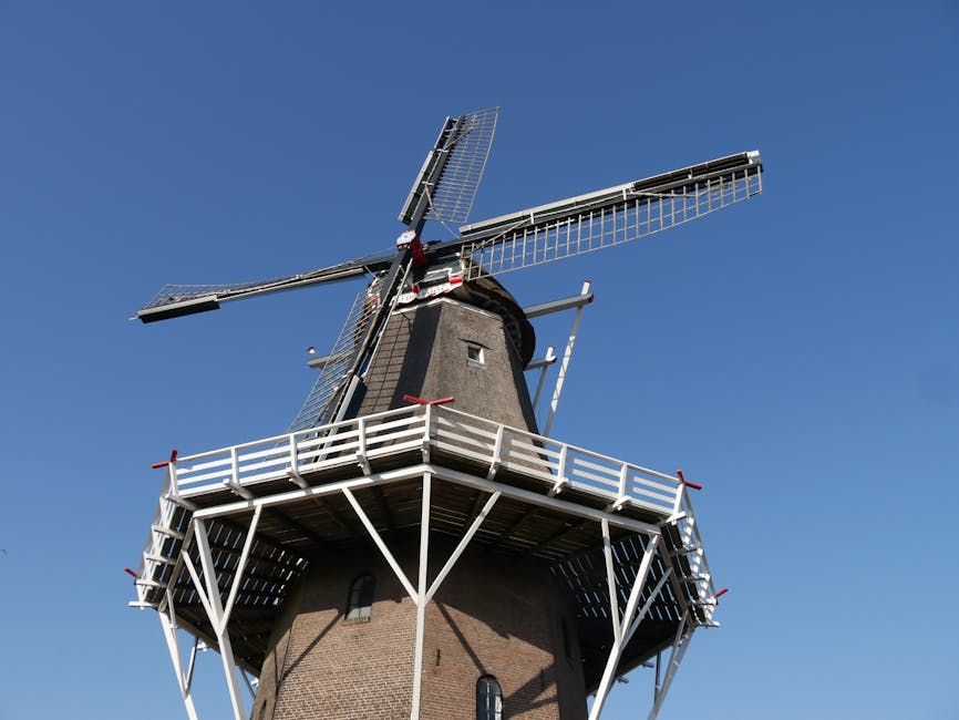 Historic Dutch windmill against a clear blue sky in Heerenveen, Friesland, Netherlands.