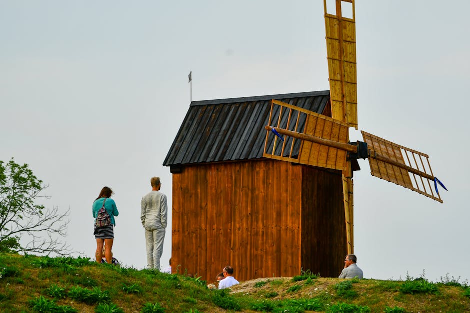 Tourists admire a historic wooden windmill in Kuressaare, Estonia.
